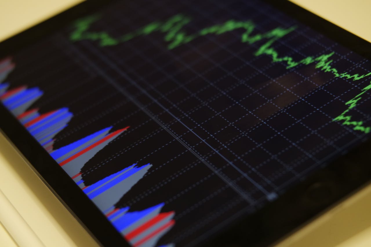 services-05 Close-up of a tablet displaying stock market analysis with colorful graphs.